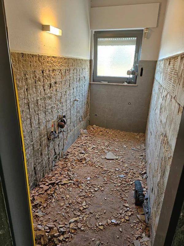 Badezimmer vor der Renovierung mit freigelegten Wänden