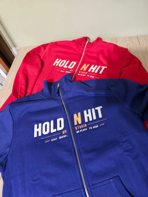 Rote und blaue Hoodies mit aufgesticktem Schriftzug